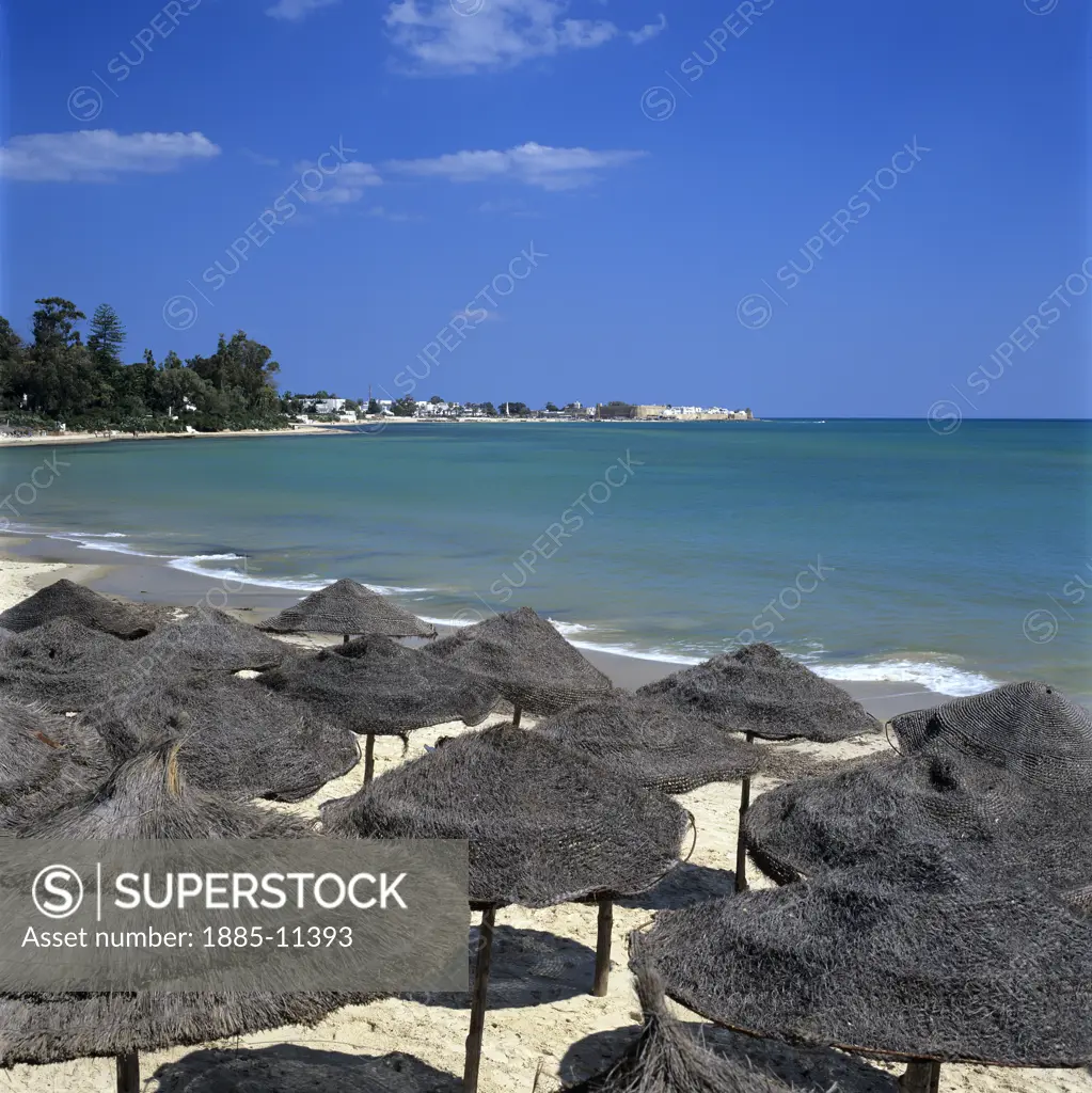 Tunisia, Cap Bon, Hammamet, Beach scene - view over straw umbrellas to the Medina