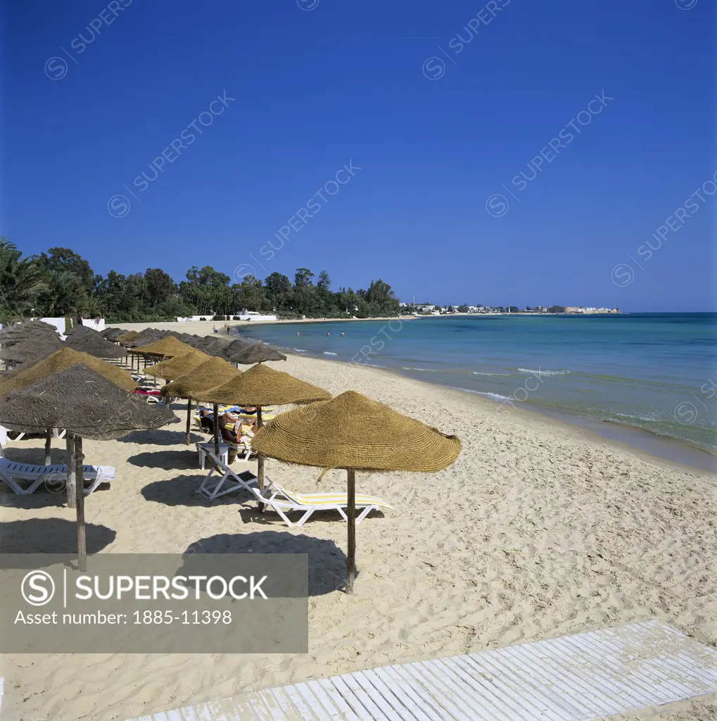 Tunisia, Cap Bon, Hammamet, Beach scene - view along beach with straw umbrellas
