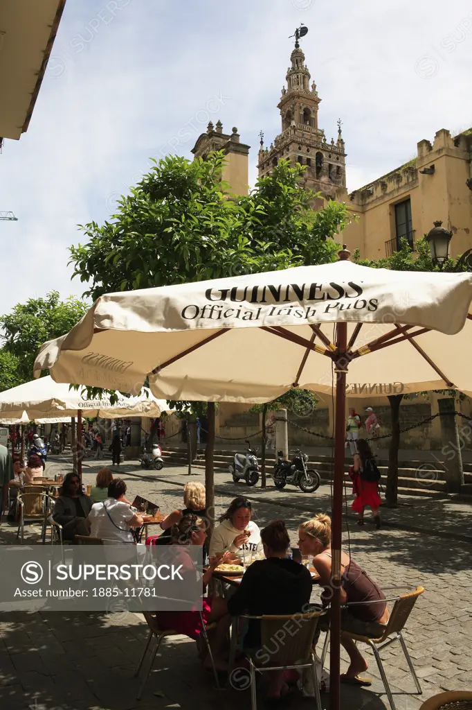Spain, Andalucia, Seville, Cafe on Avenida de la Constitucion with Cathedral in background