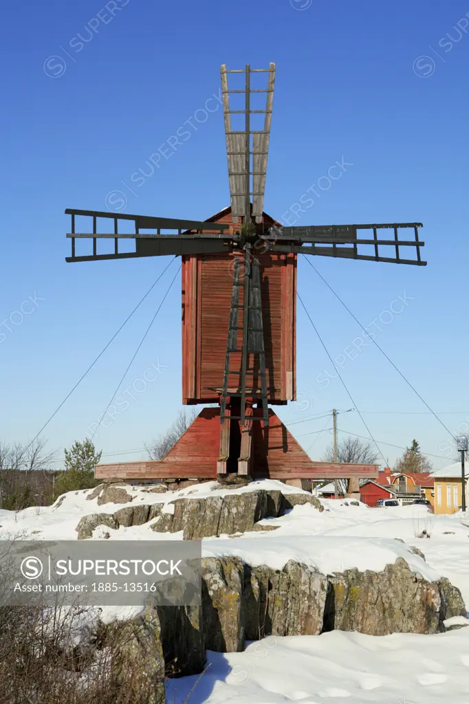 Finland, , Kristinestad, Old wooden windmill with blue sky and snow