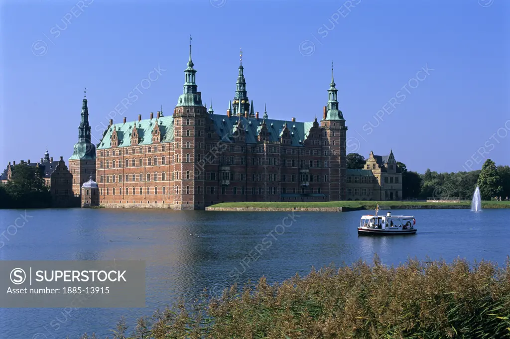 Denmark, , Hillerod, Frederiksborg Castle across lake with sightseeing boat 