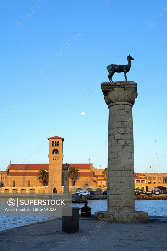 Greek Islands, Rhodes Island, Rhodes Town, Mandraki Harbour with deer statue and St Nicholas Fort at dusk