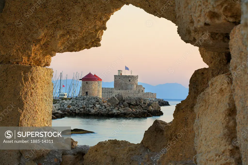 Greek Islands, Rhodes Island, Rhodes Town, Mandraki Harbour - castle and windmills viewed through wall