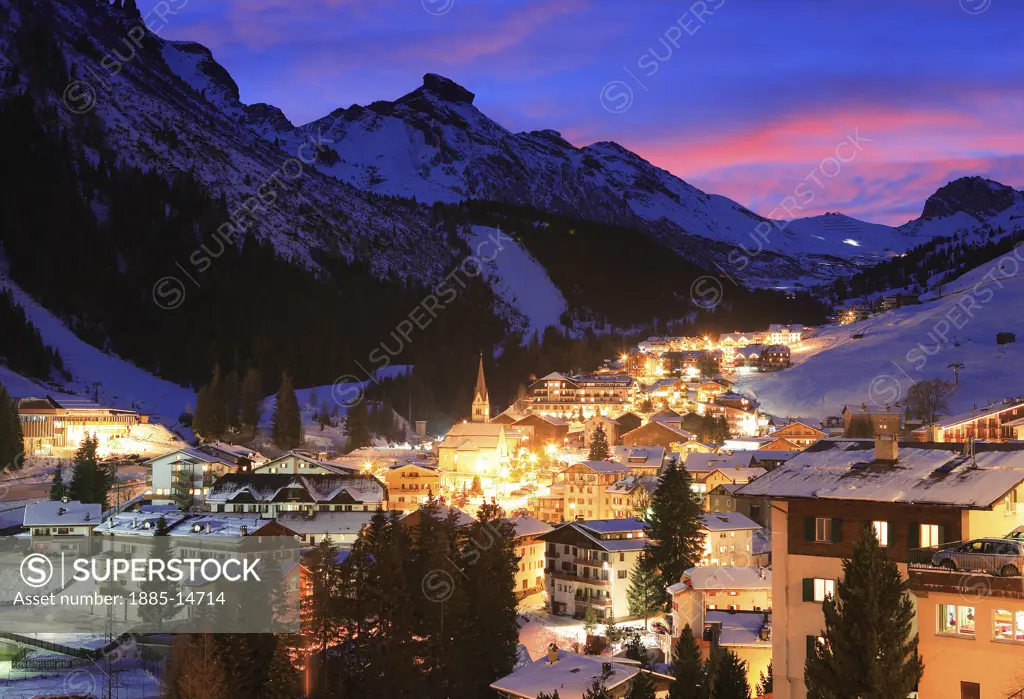 Italy, Trentino-Alto Adige, Arabba, Town and Dolomites at dusk in winter 