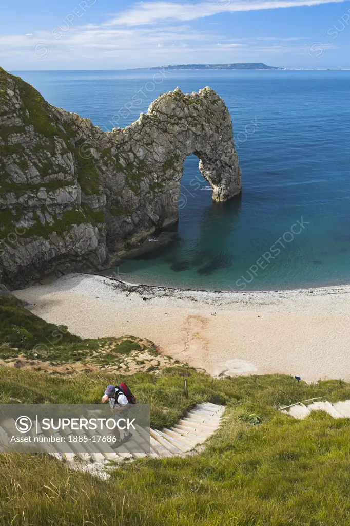 UK - England, Dorset, Durdle Door, Walker climbing steps from the beach