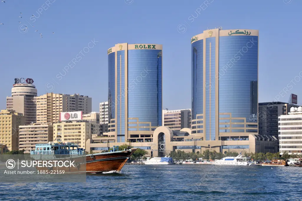 UAE, Dubai, Dubai Creek, Dubai Creek and modern architecture skyline including Rolex twin towers and passing dhow