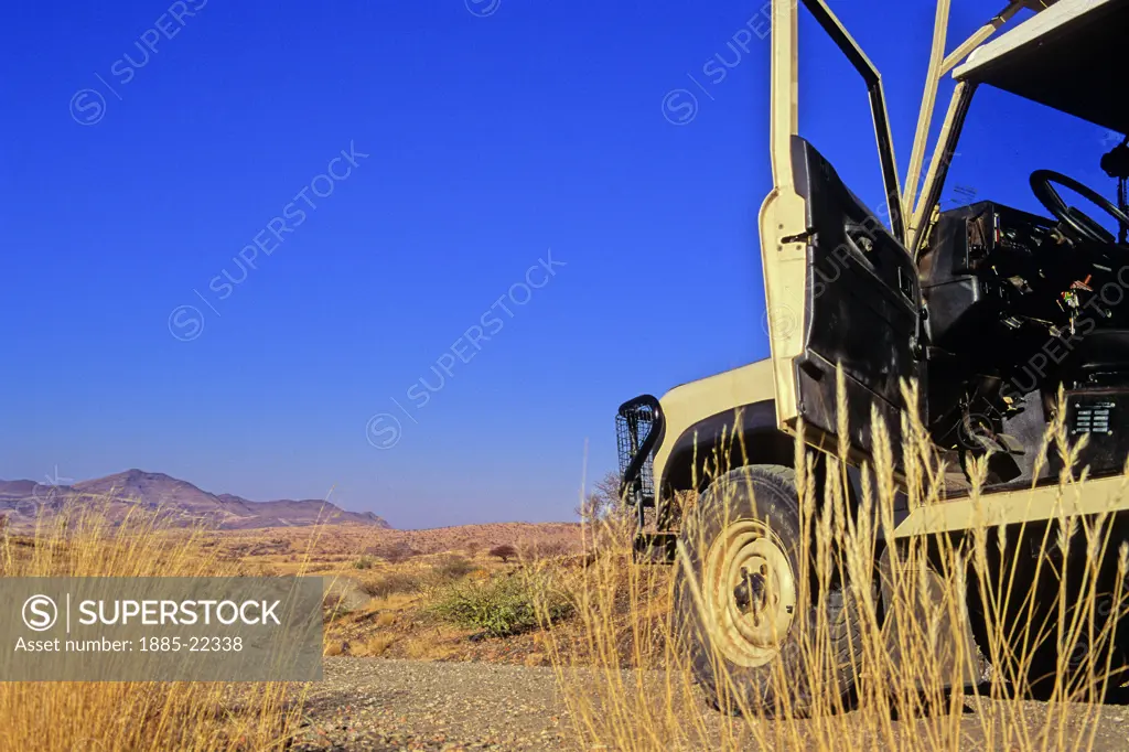Namibia, Open door of Land Rover on savanna grassland road