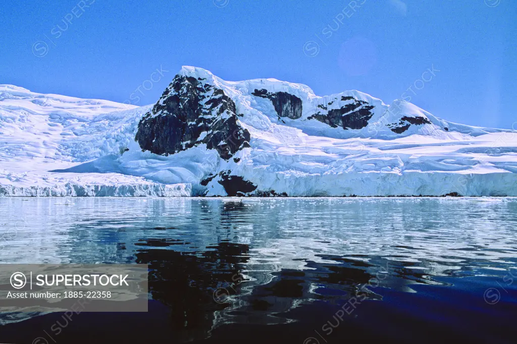 Antarctica; Antarctic Peninsula, Mirror calm water showing reflection ice glacier coastline in Antarctica