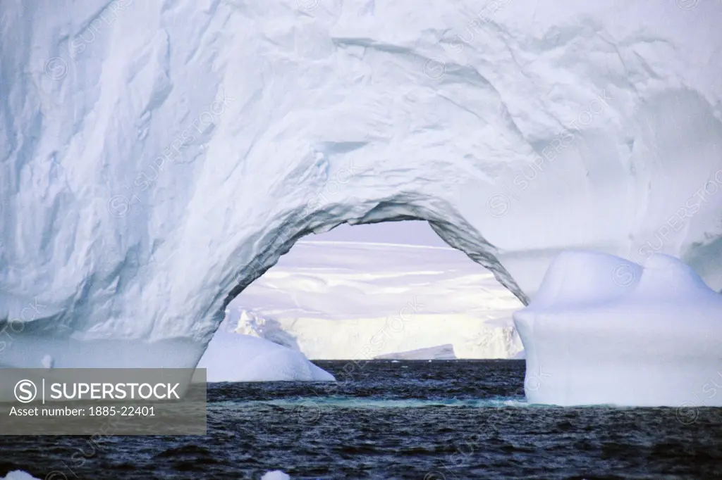 Antarctica, Antarctic Peninsula, Iceberg showing wind shaped arch and ocean water