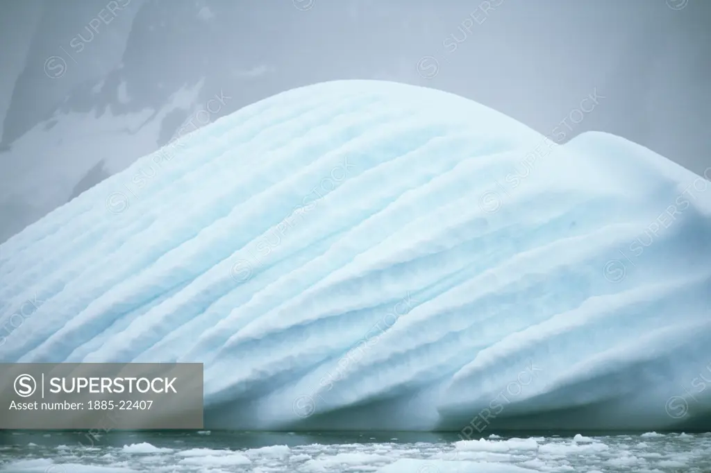 Antarctica, Antarctic Peninsula, Ice fog and cloud hangs over strange blue iceberg - revealing wind shaped surface