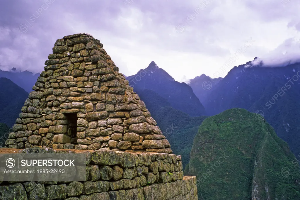 Peru, Inca ruins at Maccu Piccu - showing side of stonework house - mountain valley peaks in background
