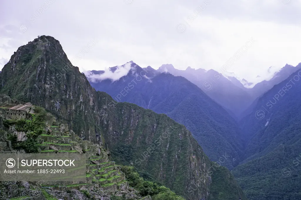 Peru, Inca ruins at Maccu Piccu - showing steep cultivation terraces - mountain valley peaks in background