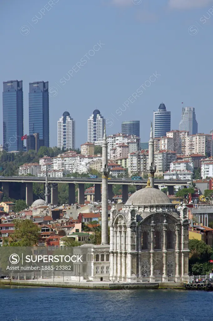 Turkey, Region, Istanbul, Istanbul Ortakoy Mosque beside the Bosphorus with high rise modern buildings on hill beyond