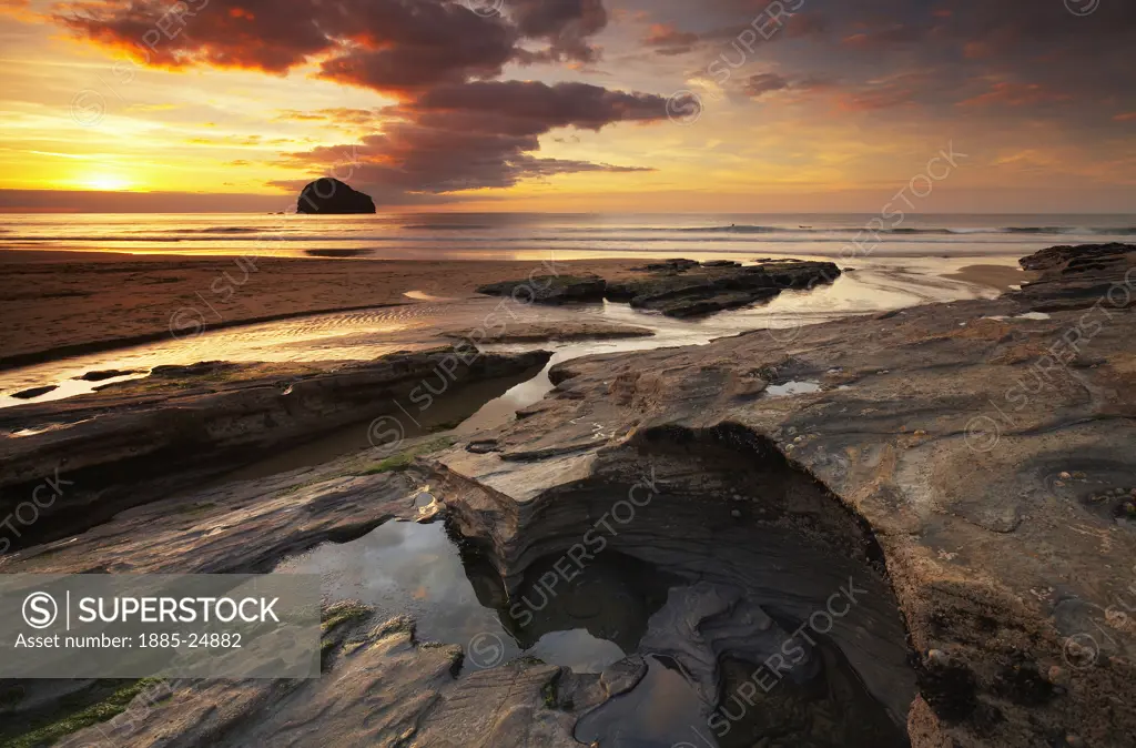 UK - England, Cornwall, Trebarwith Strand, Rocky beach at sunset