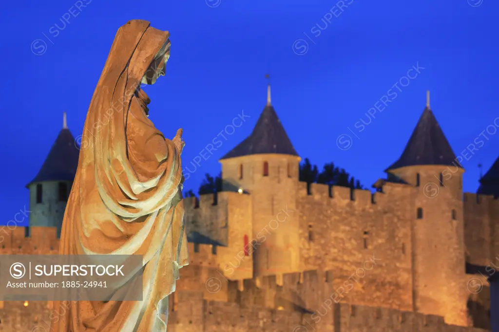 France, Languedoc-Roussillon, Carcassonne, Walled city and statue at night