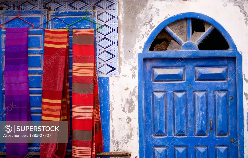Morocco, Essaouria, Colourful fabrics and blue door