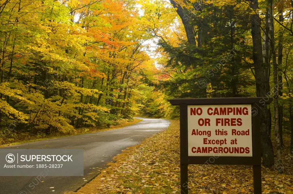 USA, New Hampshire, White Mountains National Park, Road through park in autumn with warning sign