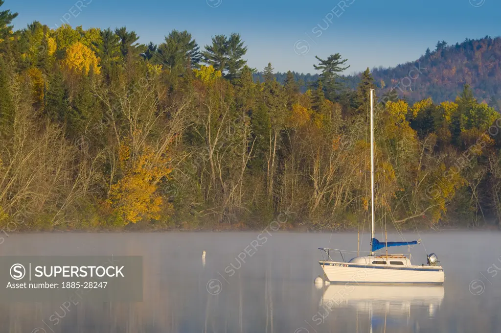 USA, New Hampshire, Lake Umbagog, Lake Umbagog with yacht in autumn