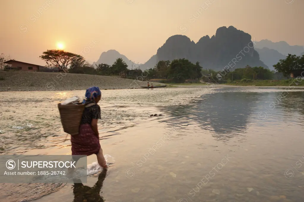 Laos, Vientiane, Vang Vieng, a woman fording the Nam Song River at Vang Vieng, Laos