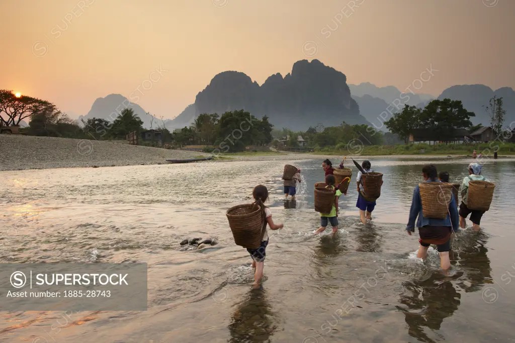 Laos, Vientiane, Vang Vieng, women and girls fording the Nam Song River at Vang Vieng, Laos