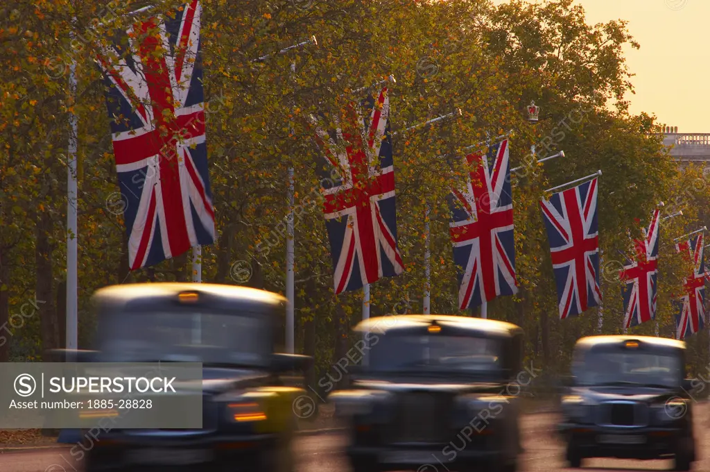 UK - England, London, Black cabs driving along The Mall at dusk