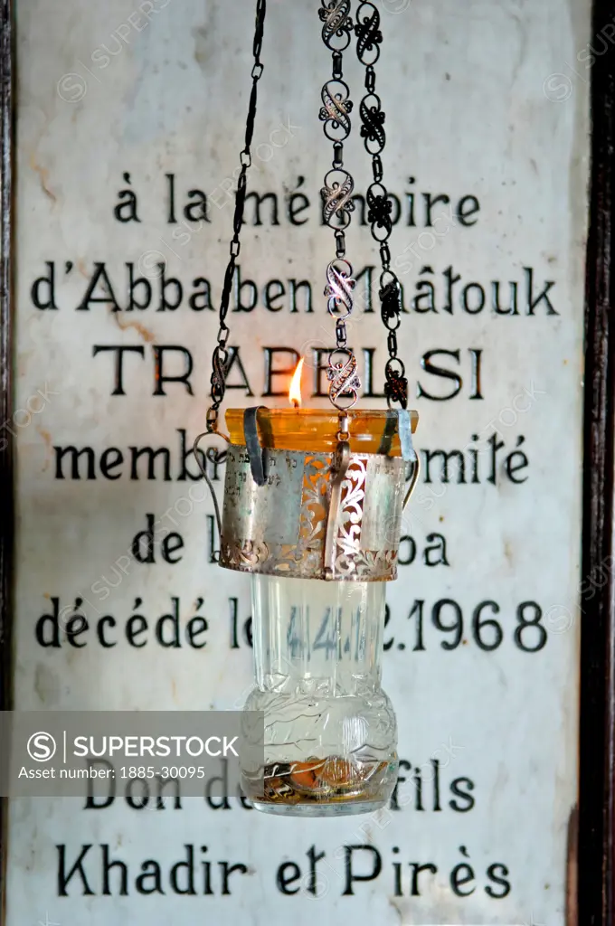 A candle burns before a commemorative plaque in El-Ghriba Synagogue at Erriadh on Jerba Island in Tunisia