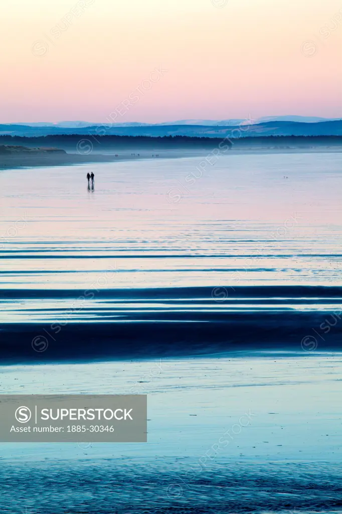 Couple Walking on The West Sands at Dusk St Andrews Fife Scotland
