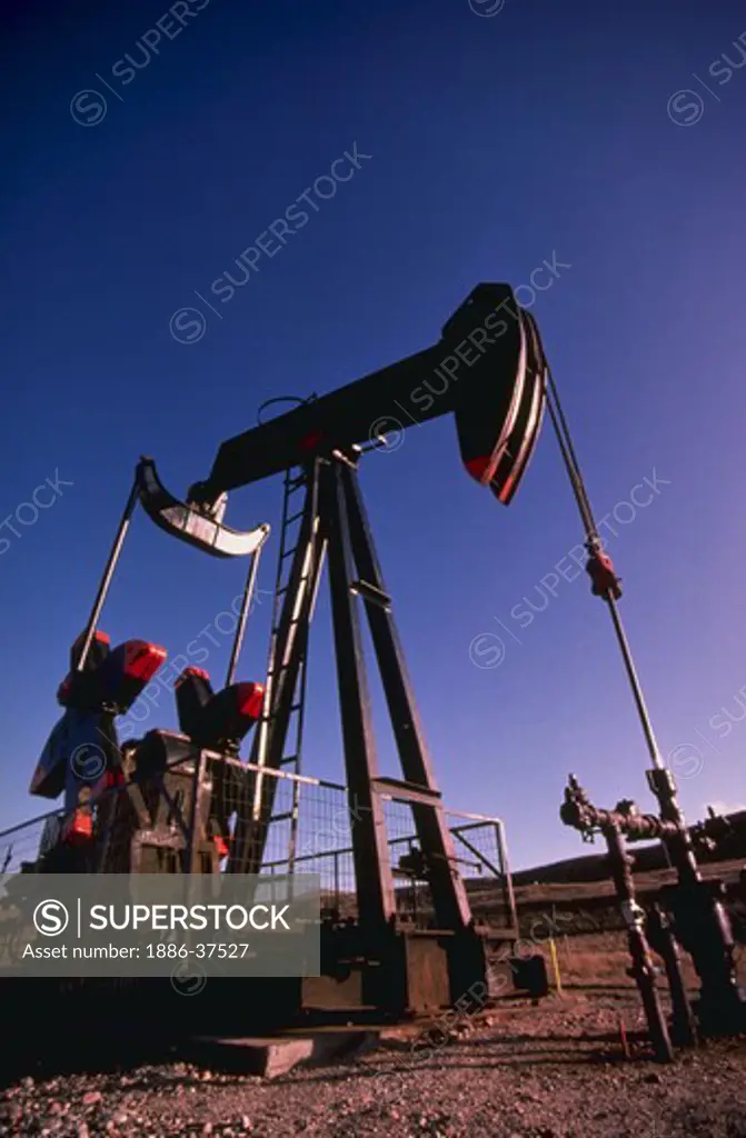 Oil well grasshopper pump in oil field in Wyoming