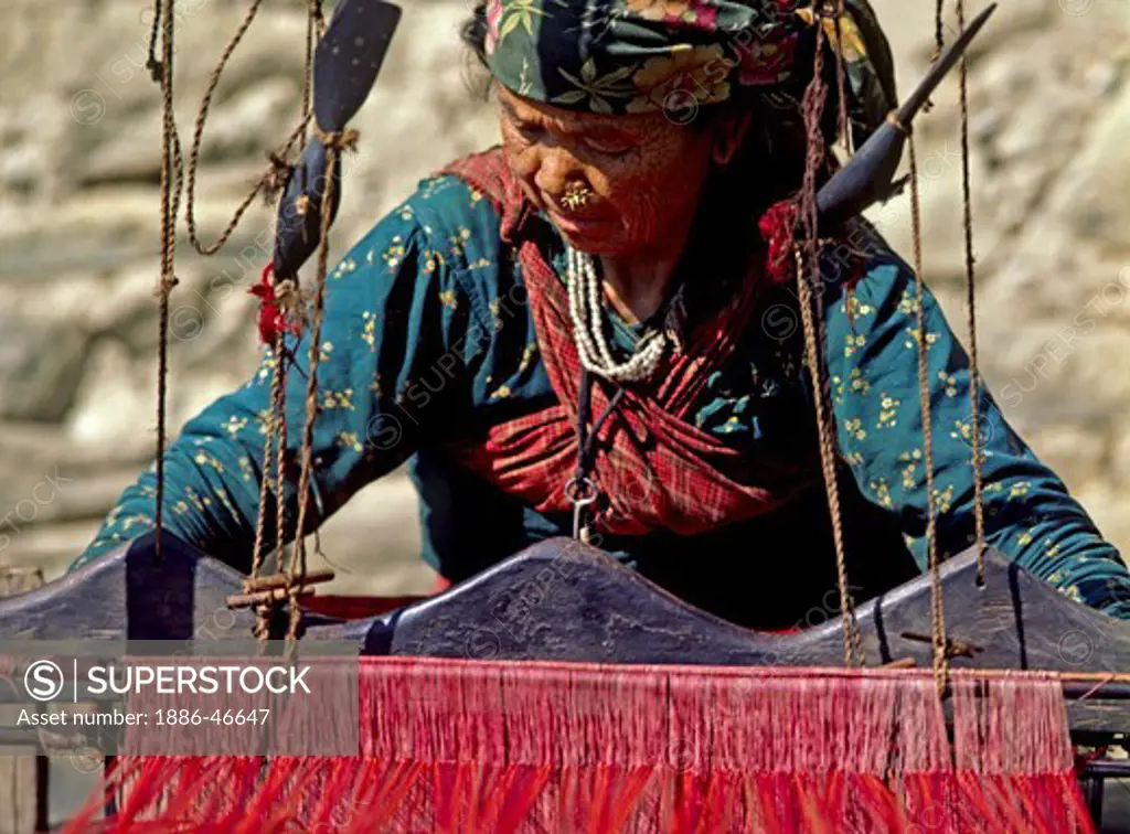Magar woman weaving red cloth - GANESH HIMAL, NEPAL