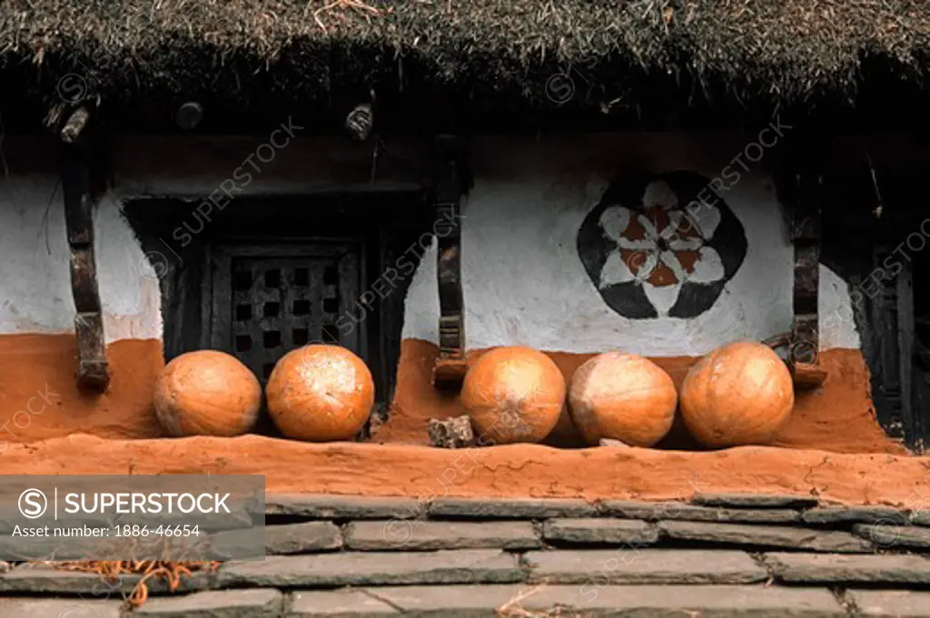 PUMPKINS are stored on the balcony of a PAINTED NEPALESE FARM HOUSE - ANNAPURNA REGION, CENTRAL NEPAL