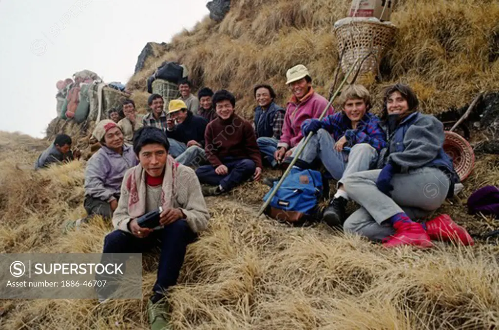 TREKKERS with a smiling group of PORTERS AND SHERPAS on a HIMALAYAN PASS - BODHA HIMAL, NEPAL