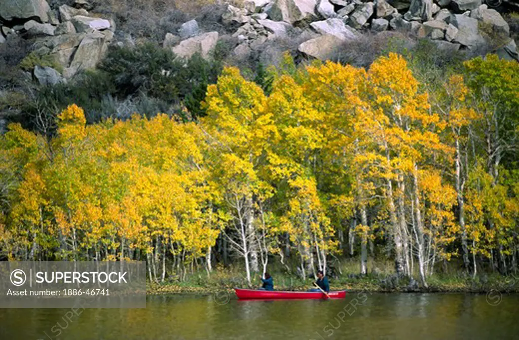 A couple enjoy canoeing on GRANTS LAKE during autumns colorful display - GRANTS LAKE, CALIFORNIA (MR)