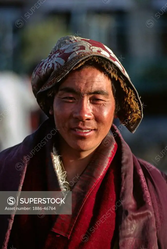 TIBETAN MAN with SILK BROCADE HAT on the BARKOR or TIBETAN Bazaar - LHASA, TIBET