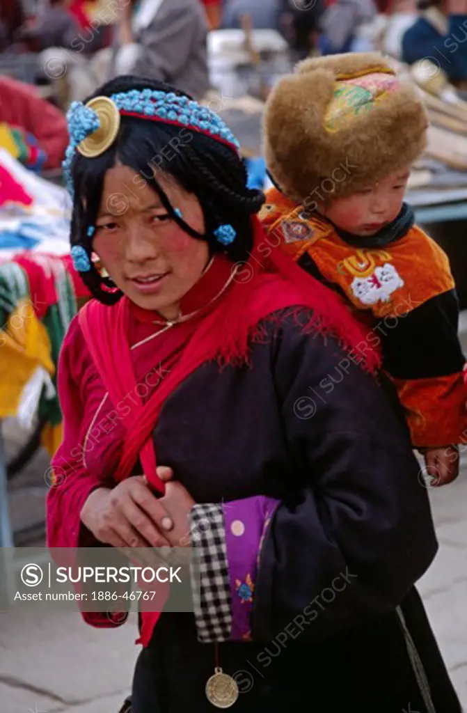 TIBETAN MOTHER & CHILD circumambulate the Jokhang Temple along the BARKOR (TIBETAN Bazaar) - LHASA, TIBET