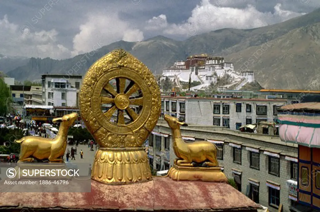 The POTALA is visible through the GOLDEN DHARMA WHEEL & DEER which adorn the roof of the JOKHANG - LHASA, TIBET
