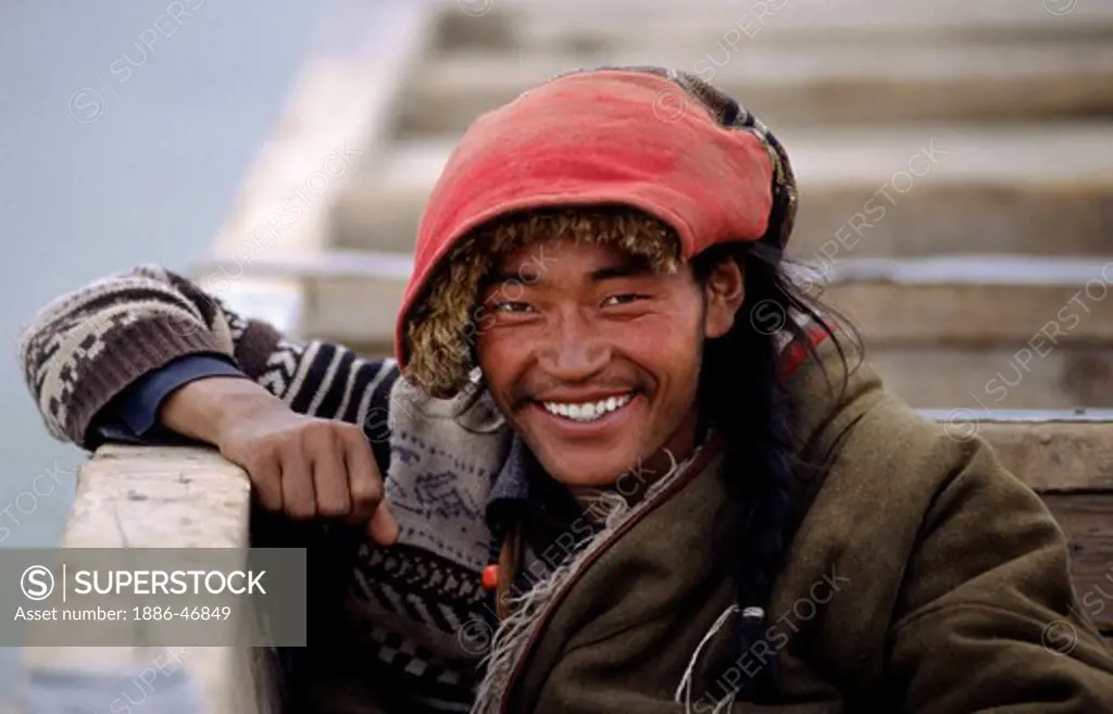 Handsome AMDO MAN sits in a boat as we cross the BRAMAHAPUTRA RIVER also know as the YARLUNG TSAMPO to SAMYE MONASTERY - TIBET