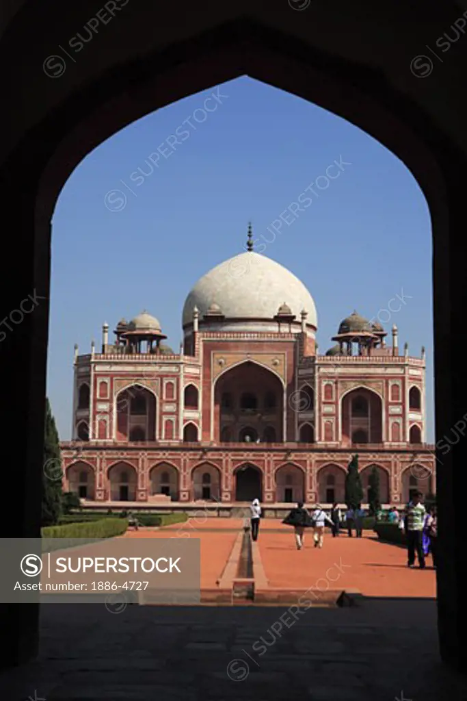 Humayun's tomb through arch built in 1570 made from red sandstone and white marble first garden-tomb on Indian subcontinent persian influence in mughal architecture ; Delhi; India UNESCO World Heritage Site