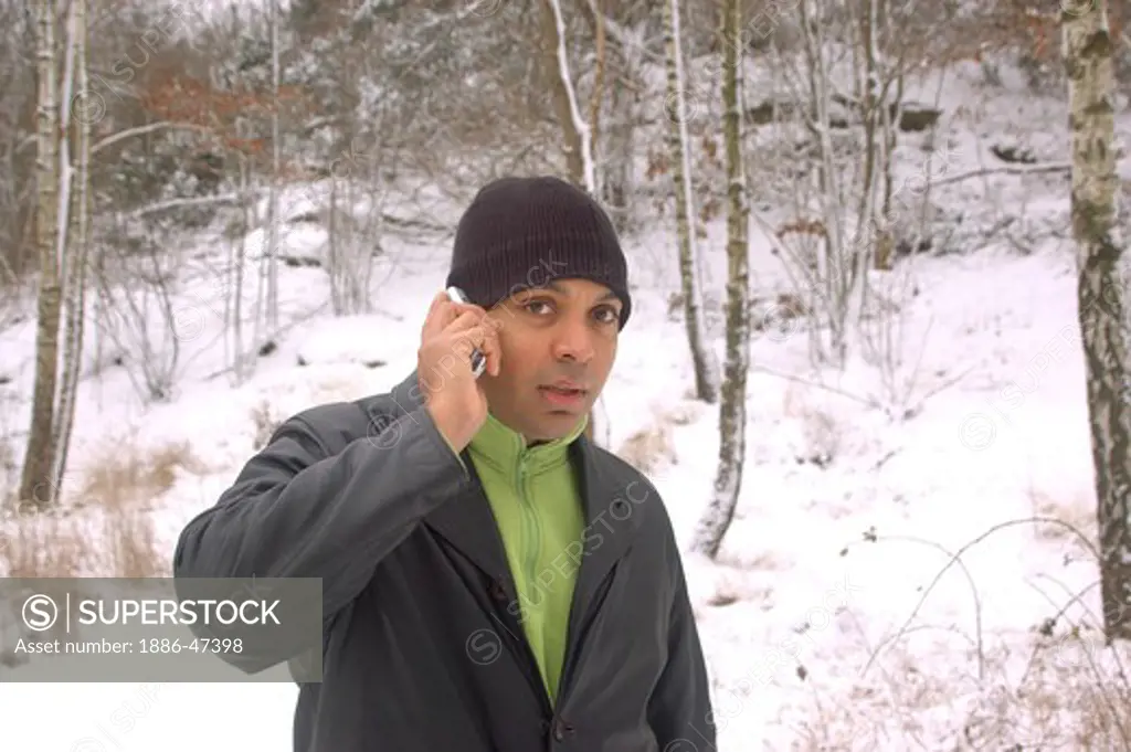 Young man talking on mobile phone from snow covered forest during winter in  Gothenburg, Sweden, MR # 468