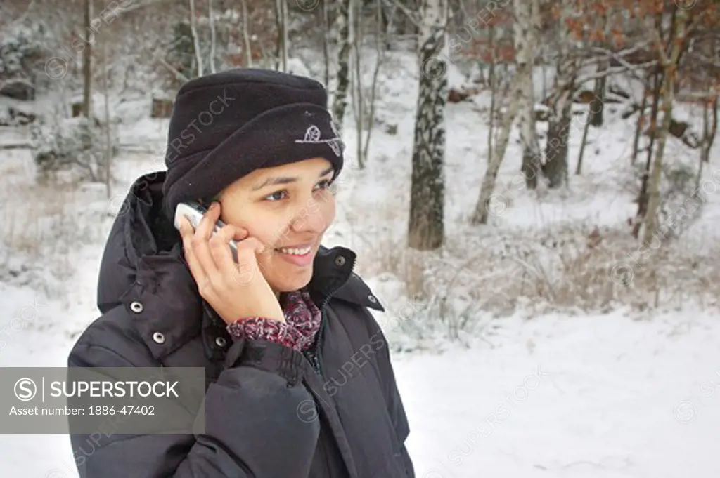 Young girl talking on mobile phone in winter clothes in winter, Sweden, MR # 468