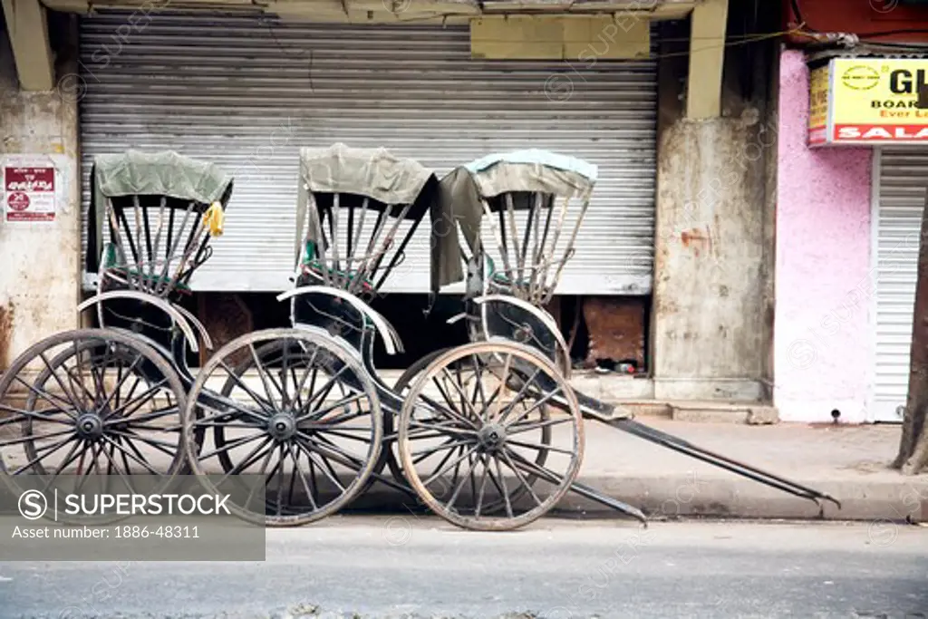 Three black color hand pulling rickshaw parked on road ; Calcutta now Kolkata ; West Bengal ; India
