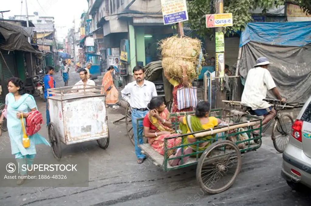 Street scene ; cycle rickshaw riders with passengers ; Calcutta now Kolkata ; West Bengal ; India