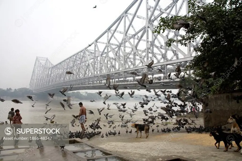 Activities on Babu ghat ; Howrah bridge over Hooghly river in background ; Calcutta now Kolkata ; West Bengal ; India