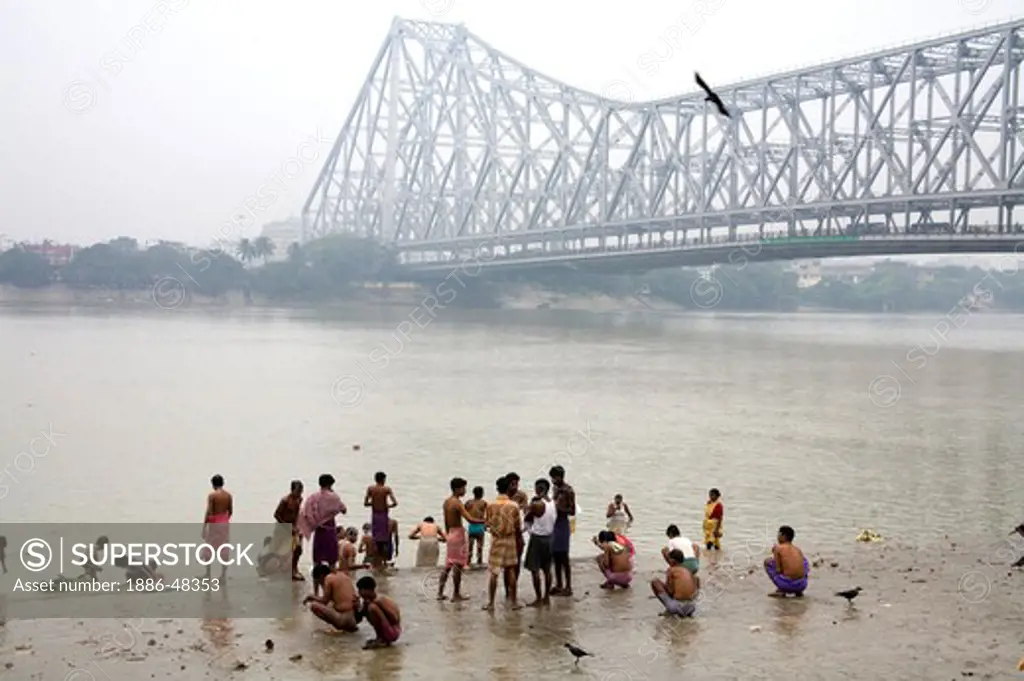 Activities on Babu ghat ; Howrah bridge over Hooghly river in background ; Calcutta now Kolkata ; West Bengal ; India