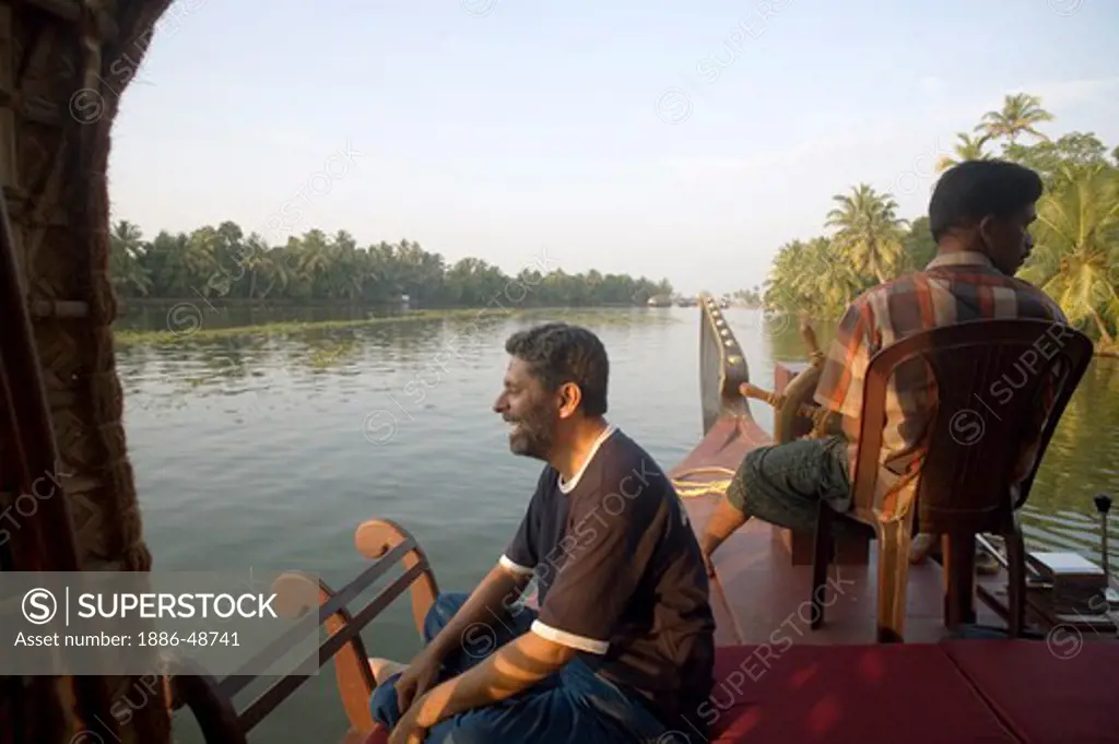 Photographer Ravi Shekar sitting on boat looking view of Backwaters ; Alleppey ; Kerala ; India MR#202