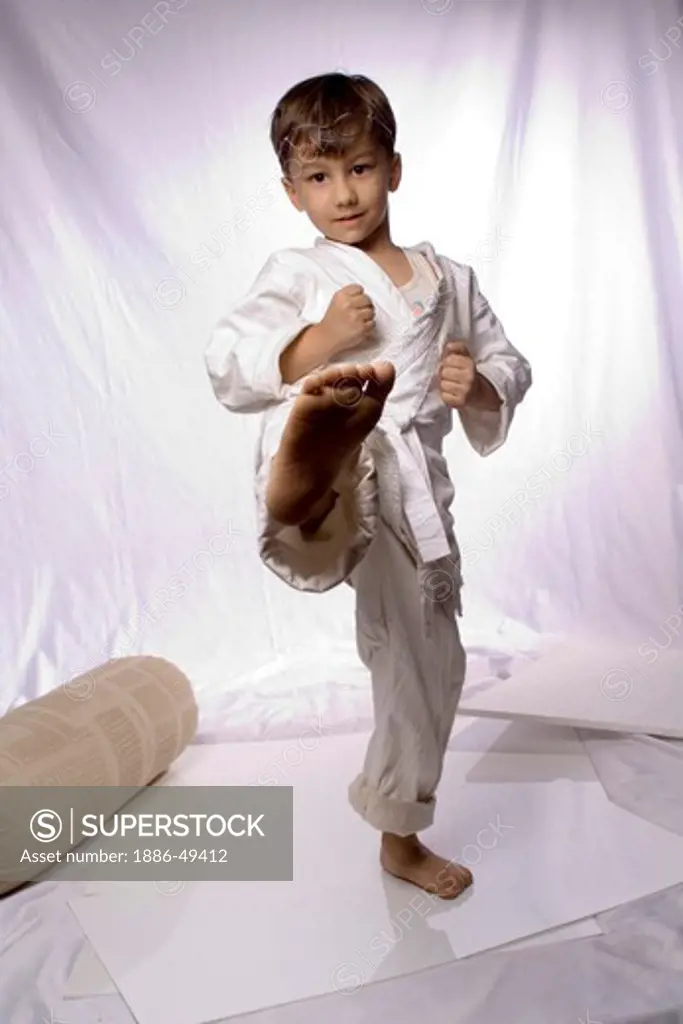 Child dressed as karate player ; boy wearing uniform and performing NO MR