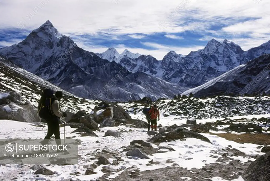 Trekkers descent from Everest Base Camp with a backdrop of Ama Dablam; Kangtega and Tamserku peaks; near Dugla; Khumbu valley; Nepal