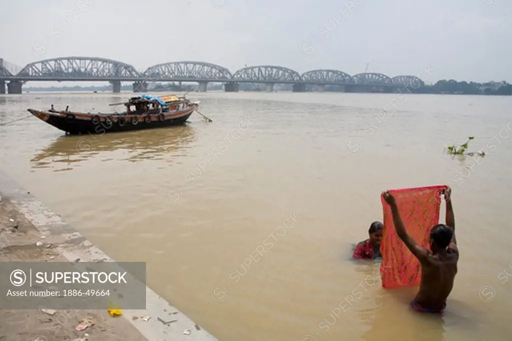 People bathing ; Dakshineshwar Hooghly river Bridge ; Calcutta Kolkata ; West Bengal ; India