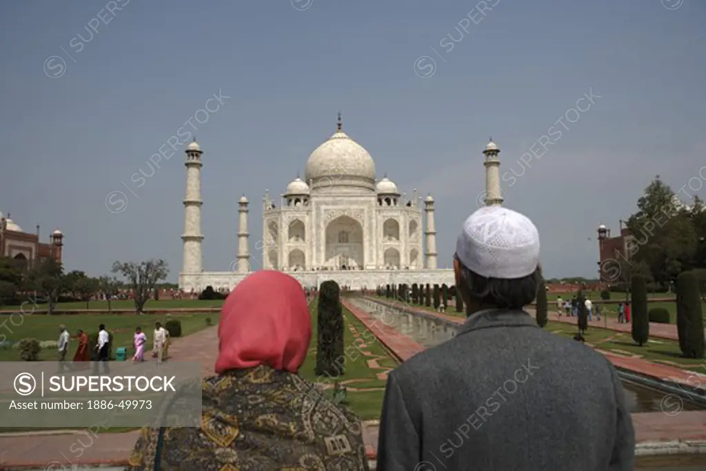 Kashmiri couple viewing at Taj Mahal Seventh Wonders of World on the south bank of Yamuna river ; Agra ; Uttar Pradesh ; India UNESCO World Heritage Site