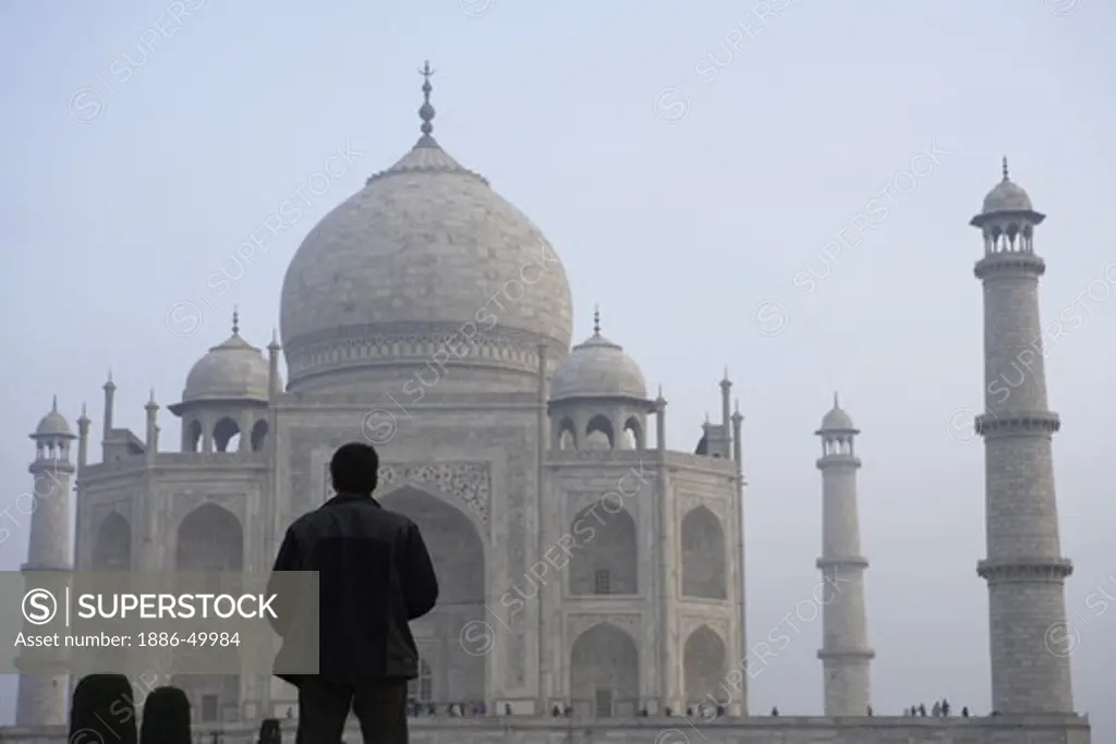 Man viewing Taj Mahal Seventh Wonders of World on the south bank of Yamuna river ; Agra ; Uttar Pradesh ; India UNESCO World Heritage Site