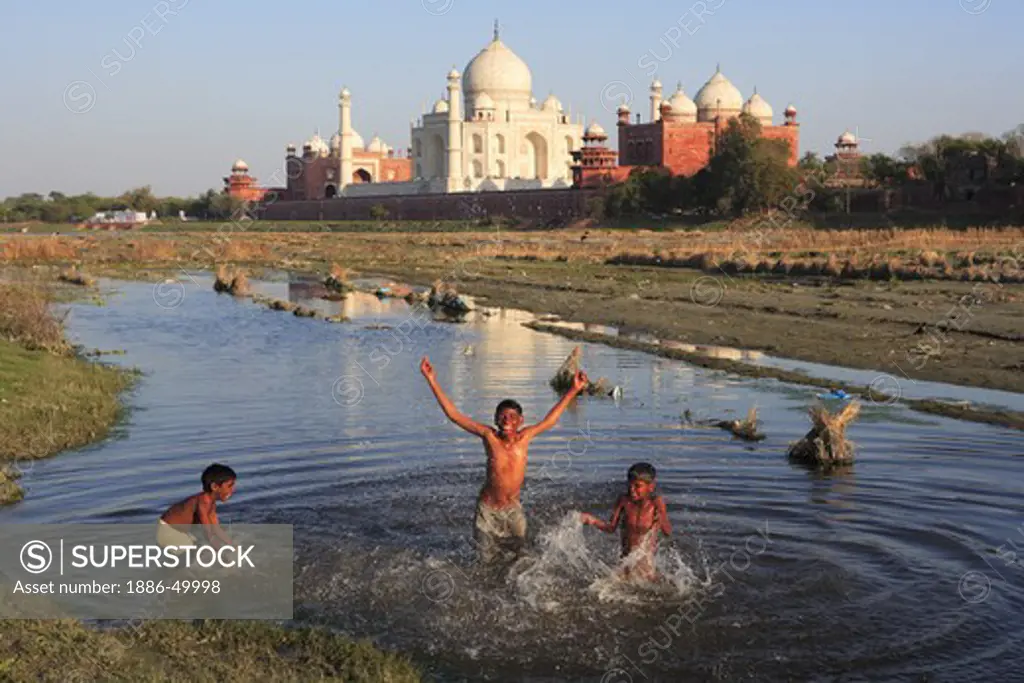 Children playing in Yamuna river at Taj Mahal Seventh Wonders of World ; Agra ; Uttar Pradesh ; India UNESCO World Heritage Site